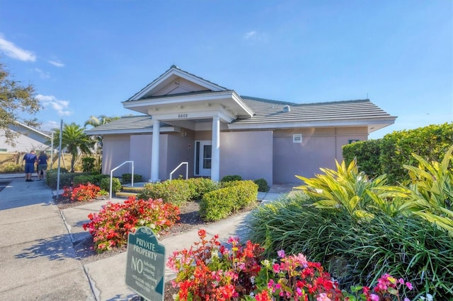single story home with stucco siding and a tile roof