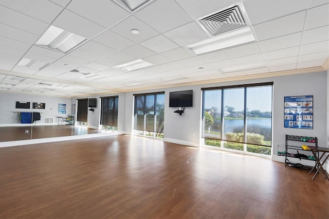 workout area featuring baseboards, wood finished floors, and visible vents