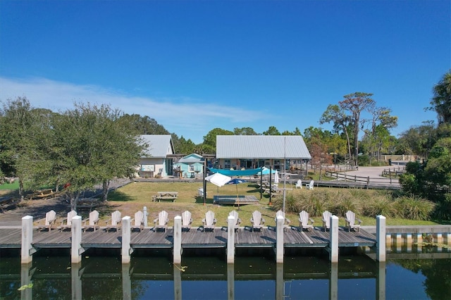 view of dock featuring a lawn and a water view
