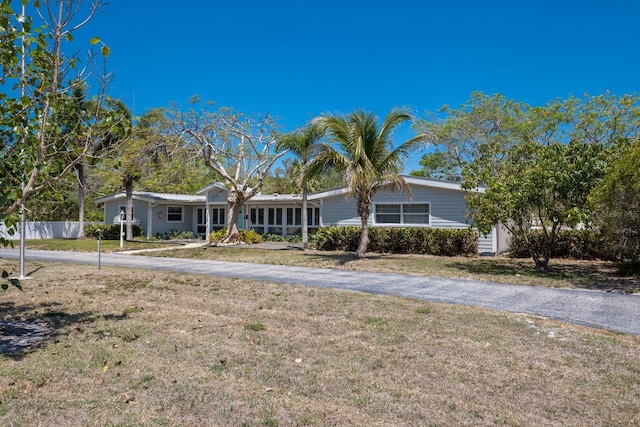 2723 59th St, Sarasota, FL 34243 - view of front of house with fence, a front lawn, and aphalt driveway