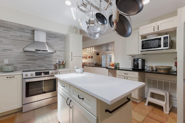 2723 59th St, Sarasota, FL 34243 - kitchen with wall chimney exhaust hood, backsplash, white cabinetry, and stainless steel appliances