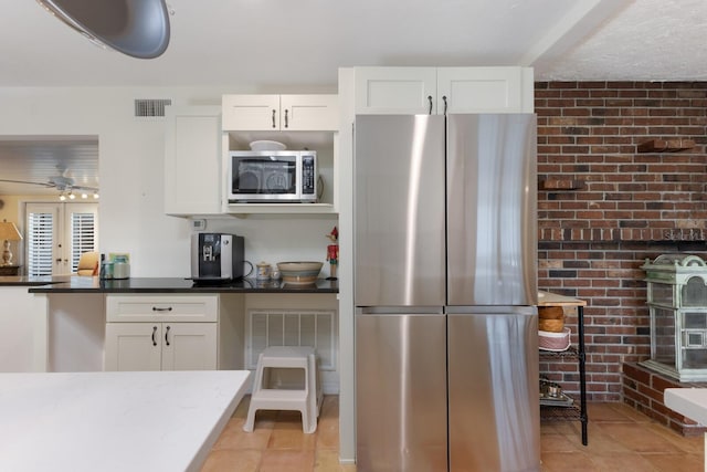 2723 59th St, Sarasota, FL 34243 - kitchen featuring light tile patterned floors, appliances with stainless steel finishes, white cabinets, and visible vents