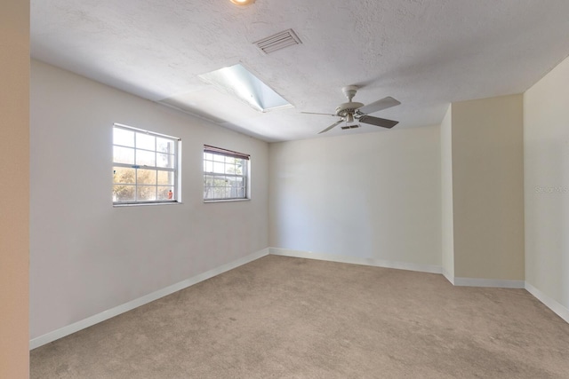 2723 59th St, Sarasota, FL 34243 - empty room featuring a skylight, visible vents, light carpet, and baseboards
