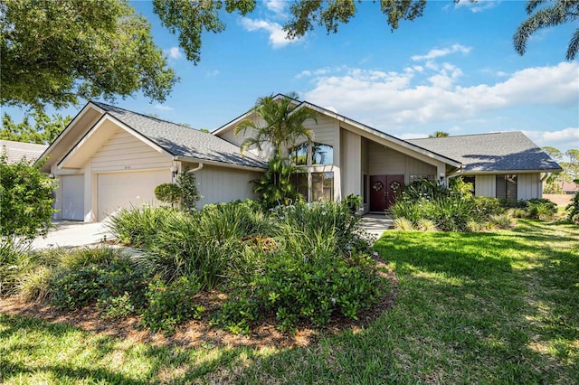 8142 Misty Oaks Blvd, Sarasota, FL 34243 - view of front facade featuring a garage, a front yard, roof with shingles, and concrete driveway