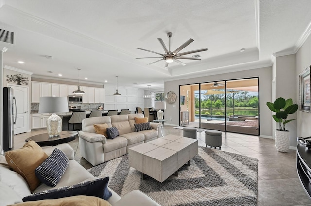 13587 Vancanza Dr, Venice, FL 34293 - living room featuring crown molding, a ceiling fan, visible vents, and a raised ceiling