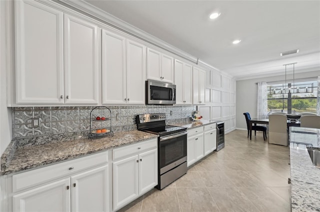 13587 Vancanza Dr, Venice, FL 34293 - kitchen featuring appliances with stainless steel finishes, white cabinetry, wine cooler, backsplash, and visible vents