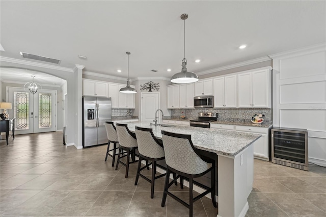 13587 Vancanza Dr, Venice, FL 34293 - kitchen with a breakfast bar, beverage cooler, light tile patterned floors, appliances with stainless steel finishes, and backsplash