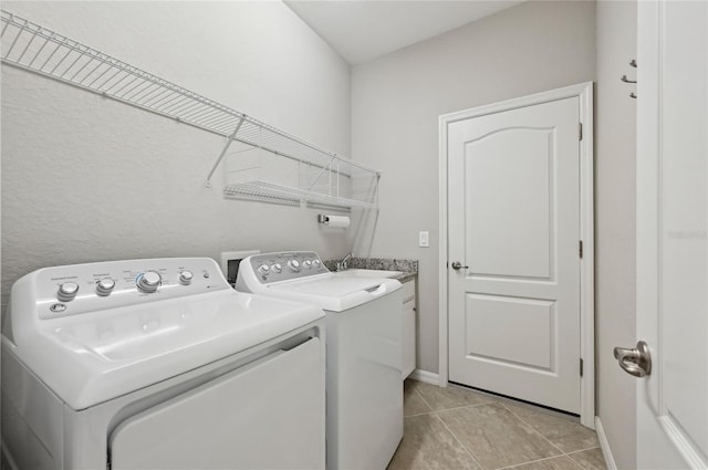 13587 Vancanza Dr, Venice, FL 34293 - laundry room with cabinet space, a sink, light tile patterned floors, baseboards, and washer and clothes dryer