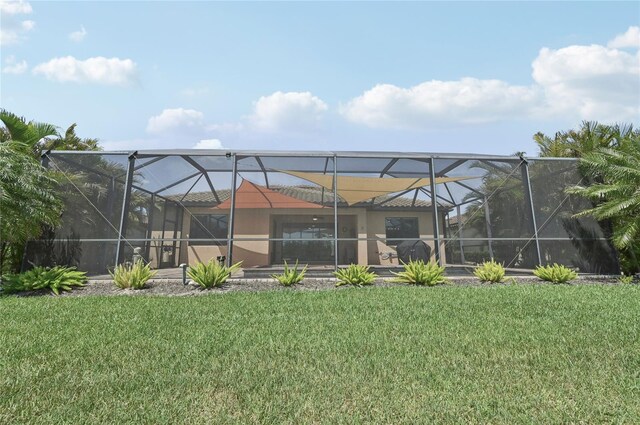 13587 Vancanza Dr, Venice, FL 34293 - rear view of property featuring a lawn and glass enclosure