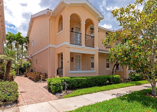 mediterranean / spanish-style home with stucco siding and a balcony