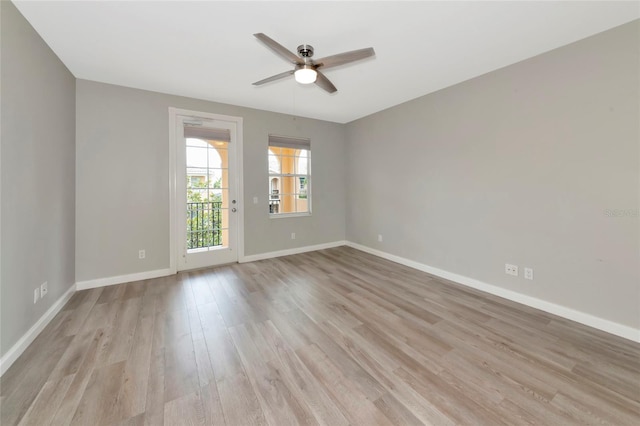 spare room with baseboards, a ceiling fan, and light wood-style flooring