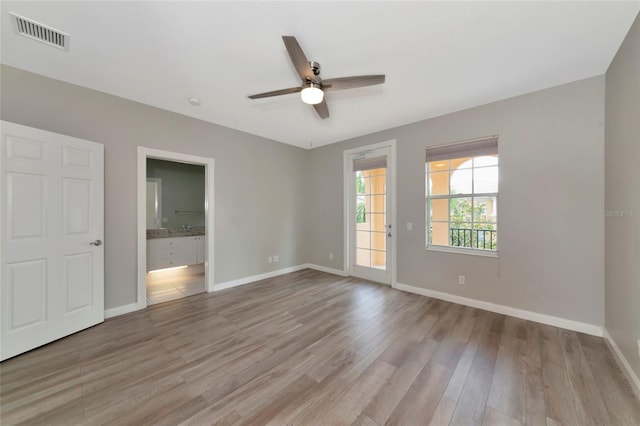 interior space with visible vents, a ceiling fan, light wood-style flooring, and baseboards