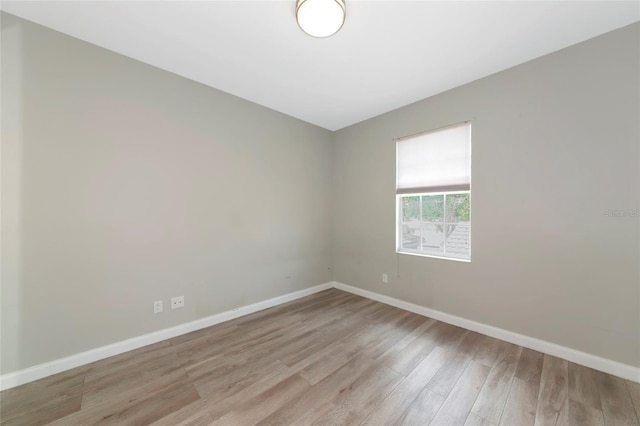 unfurnished room with baseboards and light wood finished floors