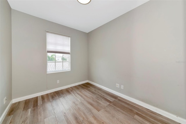 empty room with baseboards and wood finished floors