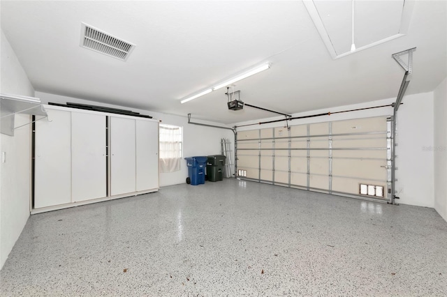 garage featuring visible vents and a garage door opener