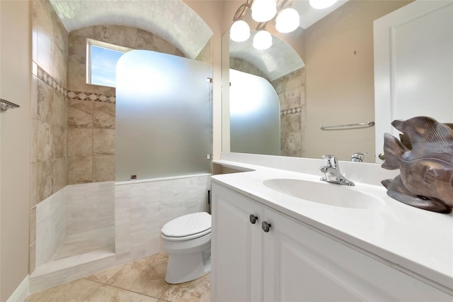 7624 Boltons Ct, Bradenton, FL 34201 - full bathroom with toilet, vanity, tiled shower, tile walls, and tile patterned flooring