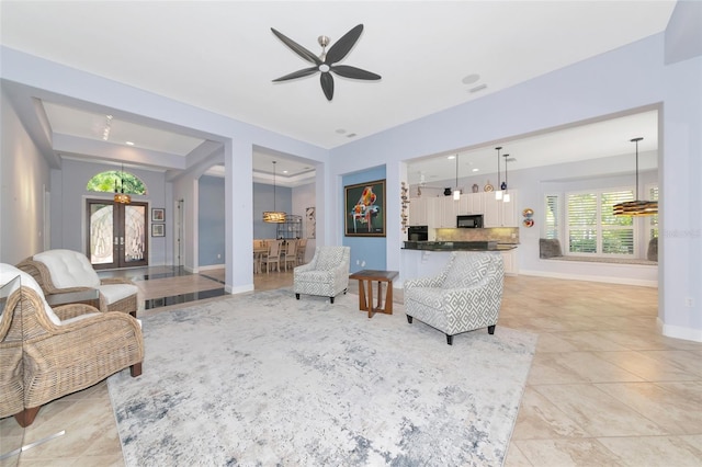 7624 Boltons Ct, Bradenton, FL 34201 - living room with ceiling fan, arched walkways, baseboards, a raised ceiling, and french doors