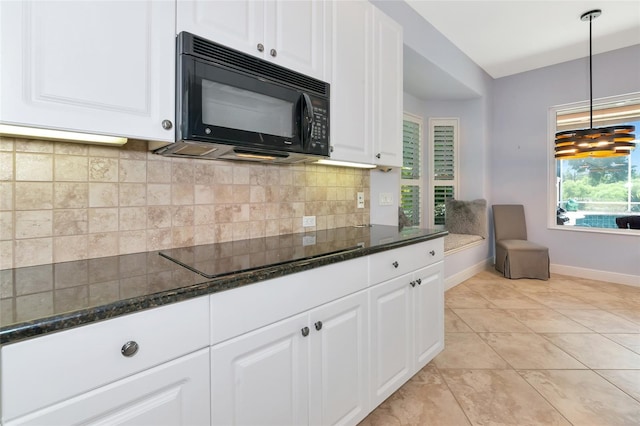 7624 Boltons Ct, Bradenton, FL 34201 - kitchen with black appliances, baseboards, white cabinets, dark stone counters, and pendant lighting