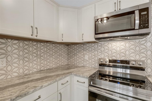 2319 Beneva Ter Unit 2284, Sarasota, FL 34232 - kitchen with appliances with stainless steel finishes, decorative backsplash, and white cabinetry
