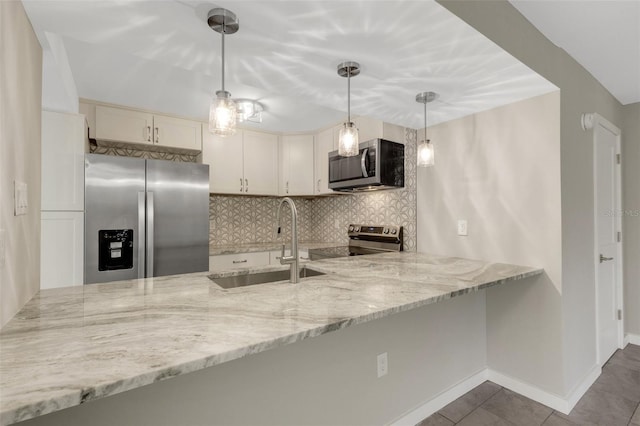 2319 Beneva Ter Unit 2284, Sarasota, FL 34232 - kitchen featuring backsplash, light stone countertops, a sink, a peninsula, and stainless steel appliances