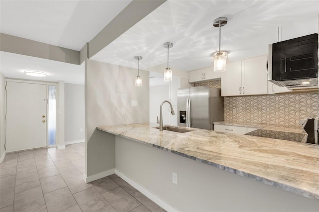 2319 Beneva Ter Unit 2284, Sarasota, FL 34232 - kitchen with light stone countertops, stainless steel fridge, a sink, a peninsula, and tasteful backsplash