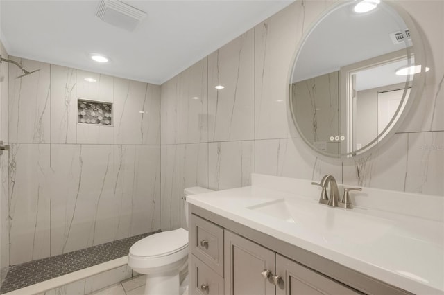 2319 Beneva Ter Unit 2284, Sarasota, FL 34232 - bathroom with visible vents, tile walls, vanity, toilet, and a marble finish shower