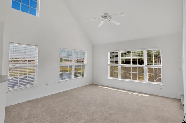 spare room with high vaulted ceiling, baseboards, a ceiling fan, and carpet flooring