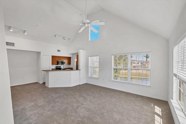 unfurnished living room with visible vents, high vaulted ceiling, rail lighting, a ceiling fan, and carpet