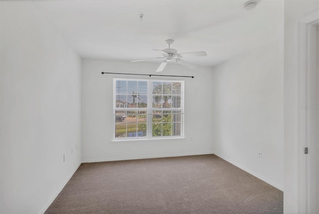 spare room featuring baseboards, ceiling fan, and carpet flooring