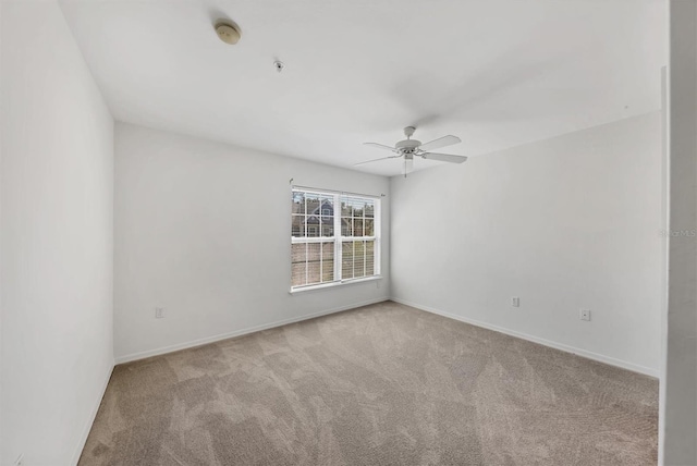 spare room featuring ceiling fan, baseboards, and carpet