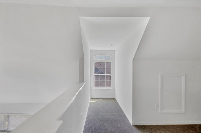 hallway with baseboards and carpet