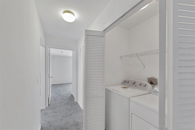 laundry room with washing machine and clothes dryer, laundry area, and light carpet