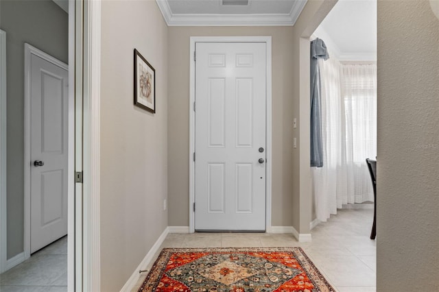 entryway featuring crown molding, baseboards, light tile patterned flooring, and visible vents