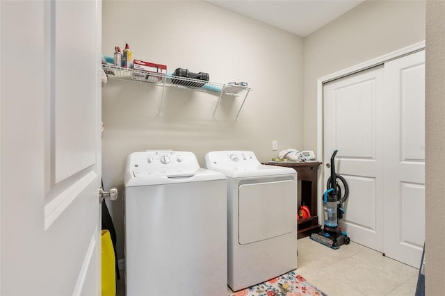 laundry area featuring light tile patterned floors, laundry area, and washing machine and dryer