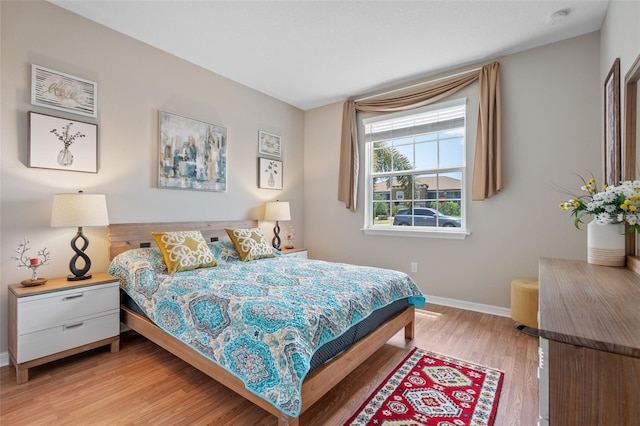 bedroom with light wood-type flooring and baseboards