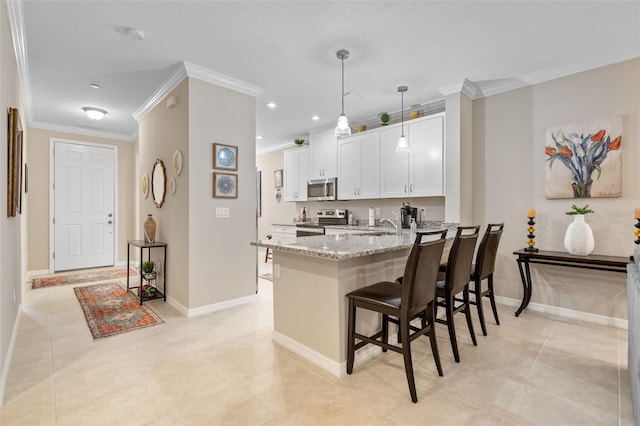 kitchen featuring appliances with stainless steel finishes, ornamental molding, light stone counters, and a breakfast bar