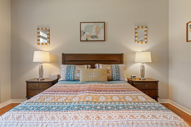 bedroom with baseboards and wood finished floors