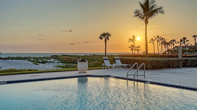 2185 Gulf Of Mexico Dr Unit 243, Longboat Key, FL 34228 - pool at dusk featuring a patio, a water view, and a community pool