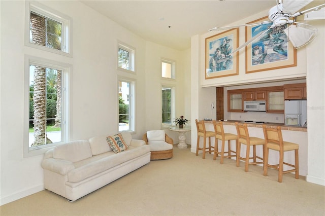 2185 Gulf Of Mexico Dr Unit 243, Longboat Key, FL 34228 - living room with a high ceiling, light carpet, ceiling fan, and plenty of natural light