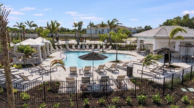 pool featuring fence and a patio area