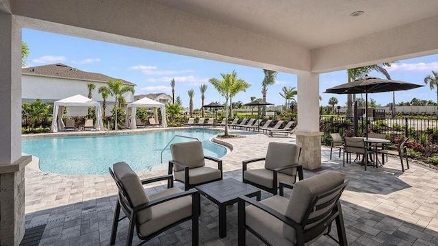 community pool featuring a gazebo, a patio area, and fence
