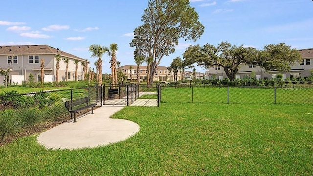 surrounding community with a yard, fence, and a residential view