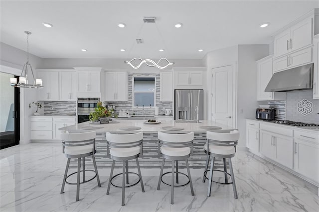 6203 Grandview Hill Ct, Bradenton, FL 34203 - kitchen featuring under cabinet range hood, appliances with stainless steel finishes, light marble finish flooring, tasteful backsplash, and recessed lighting