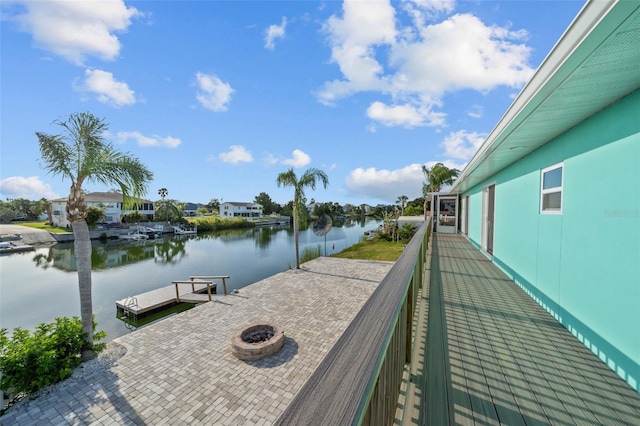 dock area with a water view and an outdoor fire pit