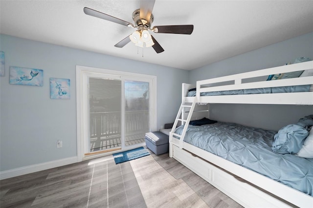 bedroom featuring baseboards, ceiling fan, wood finished floors, and access to exterior