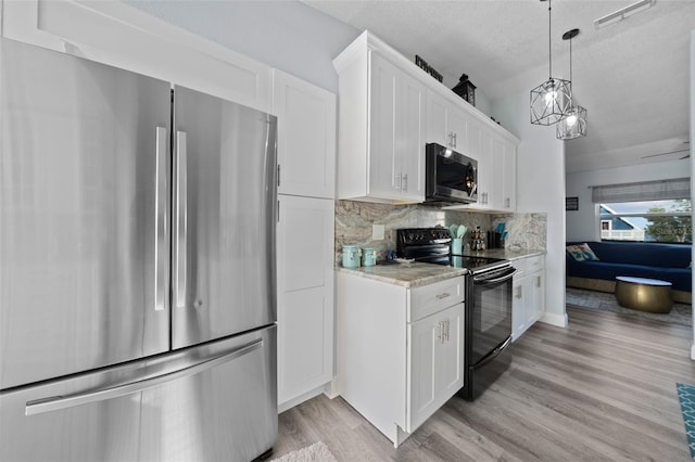 kitchen with white cabinets, light wood-style floors, a textured ceiling, stainless steel appliances, and tasteful backsplash