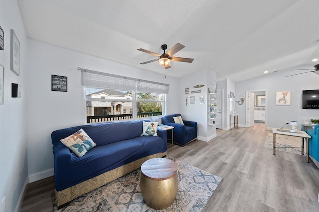 living room featuring vaulted ceiling, baseboards, a ceiling fan, and wood finished floors