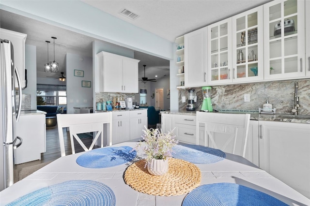 dining room with a ceiling fan, a textured ceiling, and visible vents