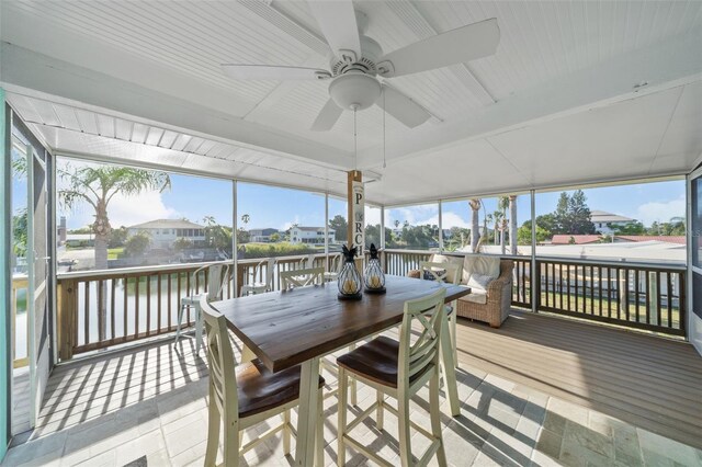 sunroom / solarium featuring a water view, ceiling fan, and plenty of natural light