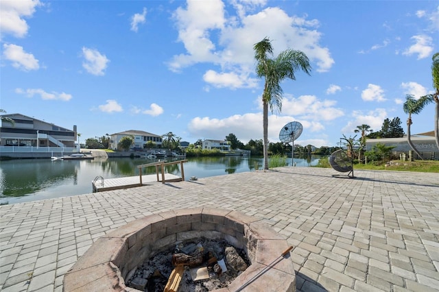 exterior space featuring a residential view, a boat dock, a water view, and an outdoor fire pit